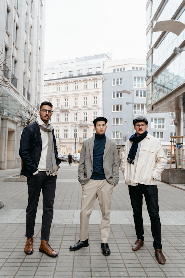 The Art of Drawing Readers In: Your attractive post title goes here Three men in stylish attire posing confidently in an urban cityscape.